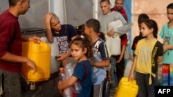 Fələstinlilər Qəzza zolağının cənubundakı Rəfahda su qablarını doldurmaq üçün növbəyə dururlar.