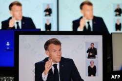 Fotografija prikazuje ekrane monitora dok francuski predsjednik Emanuel Makron govori tokom intervjua za Frans 2 i TF1 u Jelisejskoj predsjedničkoj palati.