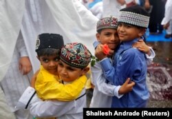 INDIA - Copiii se salută după ce au făcut rugăciuni Eid al-Fitr, care marchează sfârșitul lunii sfinte a postului Ramadan, în Mumbai, India, 26 iunie 2017.