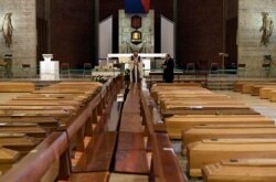 Священик освячує труни, які накопичуються в церкві через велику кількість смертей