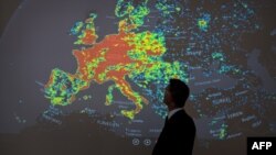 A man at a cybercrimes conference in Germany stands in front of a picture displaying the activities of a so-called botnet -- a network of computers infected with malicious software that allows a third party to control an entire computer network without the knowledge or consent of the computer owners.