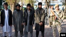 Members of the Afghan security services escort alleged members of the group calling themselves the Islamic State (IS) and Taliban, arrested during an operation in the Caperay Khar district of Nangarhar Province on January 27.