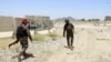 Afghan soldiers inspect the scene after overnight clashes with Taliban militants at a military base in Kandahar Province on July 26.