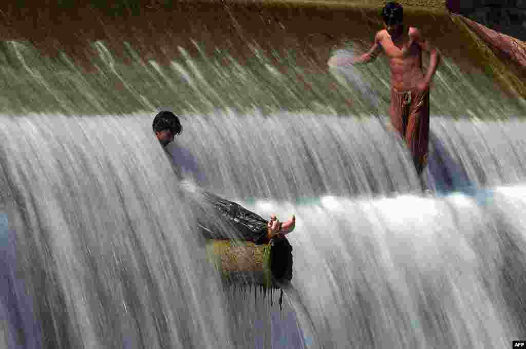 Pakistani youths cool off in a stream during hot weather on the outskirts of Islamabad. (AFP/Aamir Qureshi)