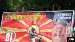 A man rides his bicycle past an upside-down billboard of opposition leader Ljube Boskovski in downtown Skopje