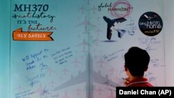 Un malaezian scriind un mesaj în cartea de condoleanțe în ziua comemorării celor 239 de oameni aflați la bordul avionului dispărut MH370