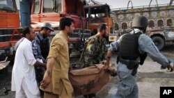 People carry a victim of a bomb attack in Jalalabad on May 18.