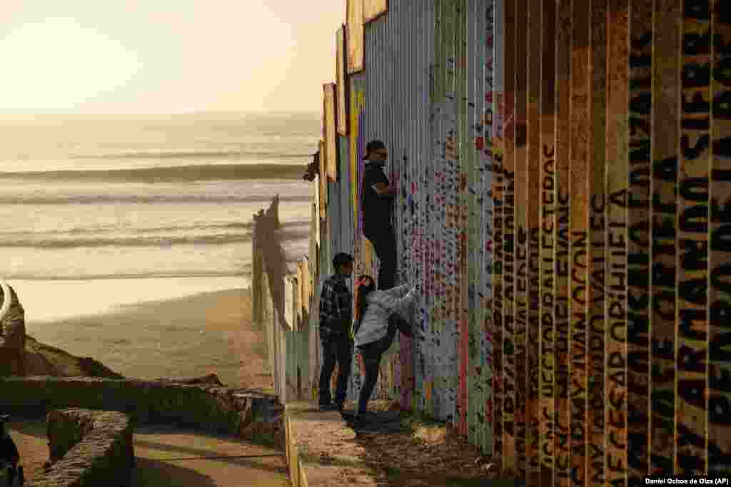 A man climbs a section of the U.S.-Mexico border wall in Tijuana, Mexico. Discouraged by the long wait to apply for asylum through official ports of entry, many Central American migrants are choosing to cross the U.S. border wall and hand themselves in to border patrol agents. (AP/Daniel Ochoa de Olza)
