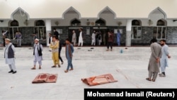 AFGHANISTAN -- Men stand outside a mosque after a blast in Kabul, June 12, 2020