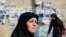 Iran -- Iranian women walk pass next to the electoral posters for the upcoming Parliamentary elections in a street of Tehran, Iran, 25 February 2016.