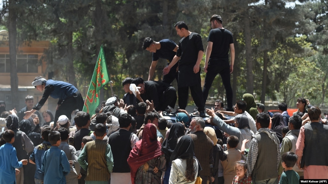 Internally displaced Afghans gather to receive food being distributed by a local charity in Kabul on August 13.