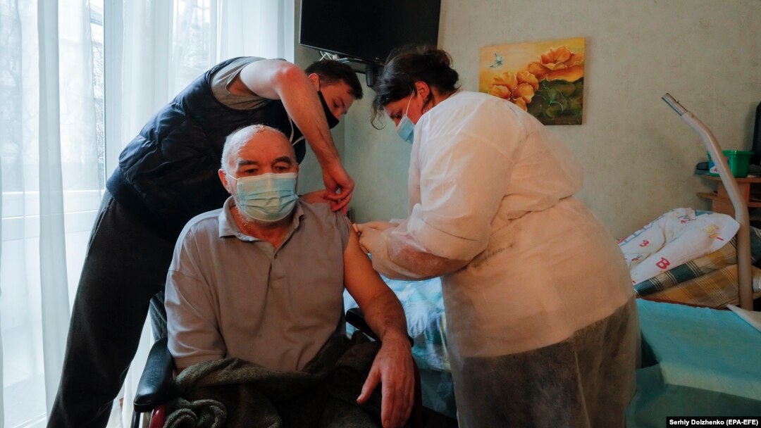 An elderly Ukrainian man receives a dose of a Chinese-developed vaccine against COVID-19 at his home in Kyiv earlier this year. 