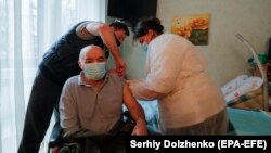 An elderly Ukrainian man receives a dose of a Chinese-developed vaccine against COVID-19 at his home in Kyiv earlier this year. 