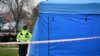 Полицейский у палатки, где проводится судебно-медицинская экспертиза перед домом убитого Николая Глушкова на юго-западе Лондона