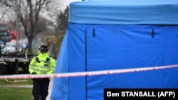 Полицейский у палатки, где проводится судебно-медицинская экспертиза перед домом убитого Николая Глушкова на юго-западе Лондона