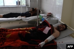 Afghan men are treated in a hospital after being injured in a car-bomb attack in Kabul on July 24.