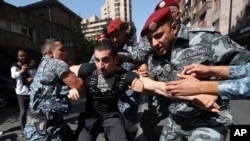 Police officers detain a demonstrator during a protest against Prime Minister Nikol Pashinyan in Yerevan on September 22.