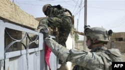 Iraqi and U.S. troops search a neighborhood of Ba'qubah in late July.