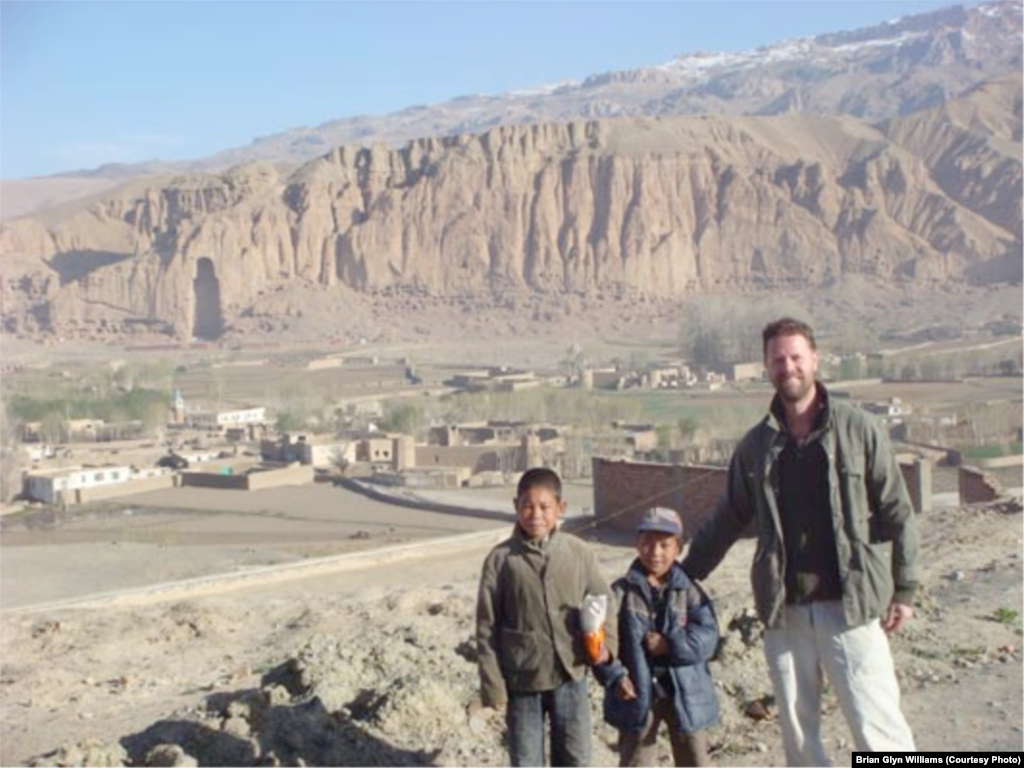 With Hazara children in the Vale of Bamiyan located at 8,000 feet in the remote Hindu Kush Mountains. In the background is an empty niche in the rock face where Afghanistan&rsquo;s most famous historic monument, one of two magnificent 6th-century carvings of Buddha, once stood. The two giant stone carvings were blasted to rubble by the Taliban in March 2001 after the hard-line Islamists labeled them a &ldquo;pagan idol.&rdquo;