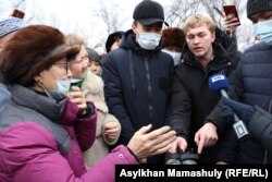 Житель Алгабаса показывает представителю акимата Бектасу Сабитову (в центре) обувь своего ребенка после прогулки по улицам микрорайона. Алматы, 21 февраля 2021 года.