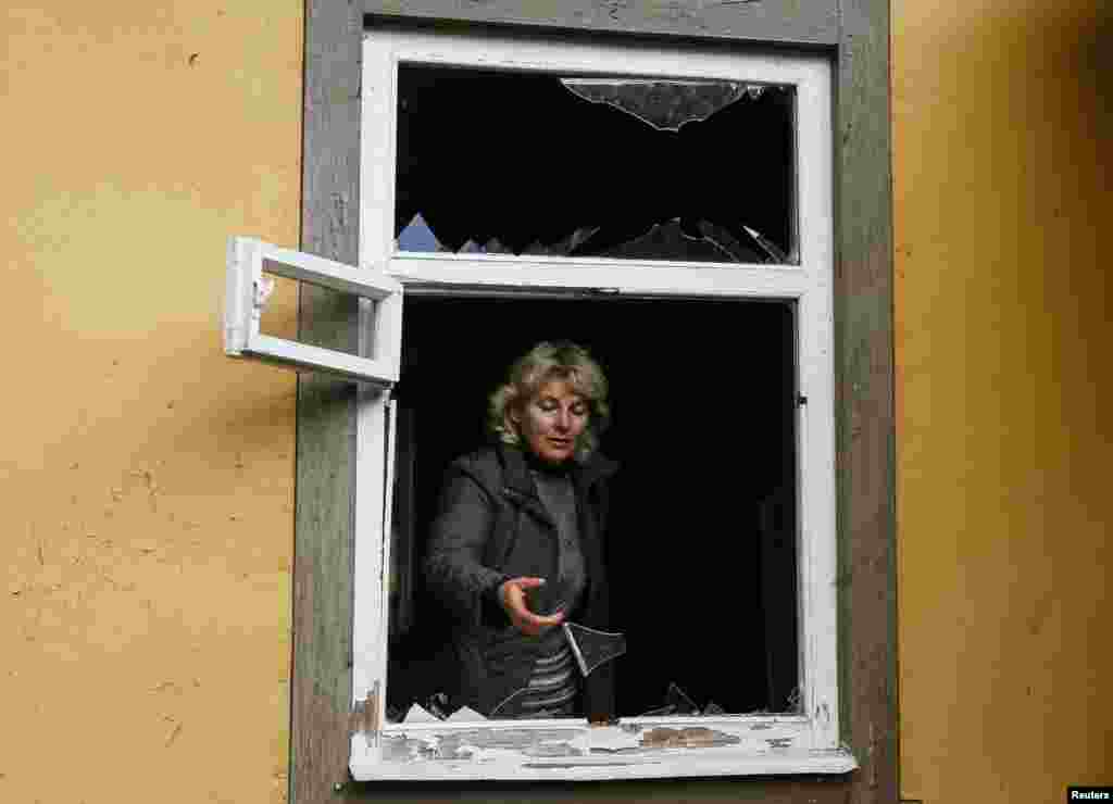52-гадовая Валянціна Пятрэнка каля разьбітай выбухамі шыбы ў сваёй хаце ў вёсцы Дружба