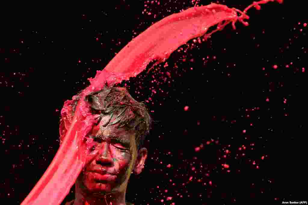 An Indian reveler is hit by colored water during Holi festival celebrations in Chennai. Holi, the popular Hindu spring festival of colors, is observed in India and many other countries at the end of the winter season on the last full moon of the lunar month. (AFP/Arun Sankar)