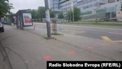 Crvena boja na trotoaru ko znak za bezbedan razmak na stanicama gradskog prevoza u Beogradu. Ggradske vlasti označili su mere za stajanje, po pravilima fizičkog distanciranja u cilju borbe protiv korona virusa. Zabeleženo 6. maja 2020.