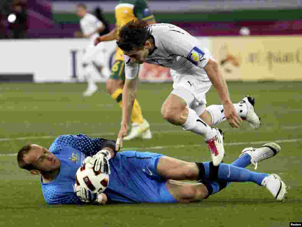 Qatar -- Australia vs. Uzbekistan at the 2011 Asian Cup semi-final soccer match in Doha, 25Jan2011 - Australia's goalkeeper Mark Schwarzer (L) makes a save against Uzbekistan's Server Djeparov during their 2011 Asian Cup semi-final soccer match at Khalifa stadium in Doha January 25, 2011. REUTERS/Suhaib Salem (QATAR - Tags: SPORT SOCCER)