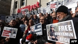 Turkish journalists hold placards with images of Bunyamin Aygun, a photographer working for Istanbul daily "Milliyet," who was abducted in Syria by armed opposition groups, during a protest in Ankara on December 23, 2013.