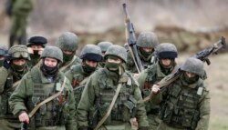 Російські військовослужбовці у формі без розпізнавальних знаків марширують біля української військової частини в Перевальному, 5 березня 2014 року