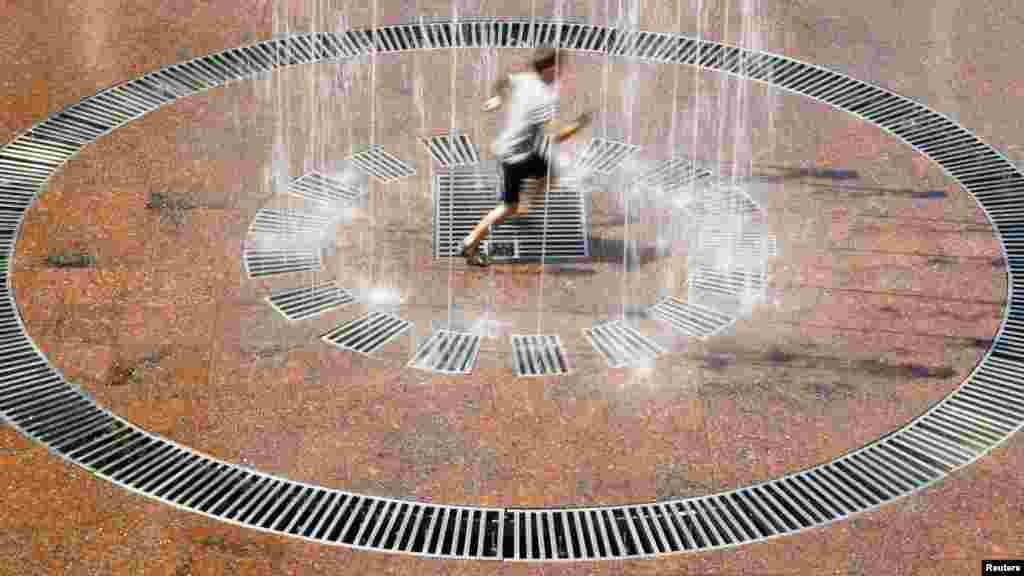 A boy plays in a fountain during a spell of hot weather in the center of Kyiv. (Reuters/Anatolii Stepanov)