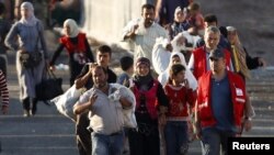 Newly arrived Syrian refugees walk to their tents in the Turkish border town of Reyhanli in Hatay province.