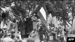 Мешканці Будапешта з угорським прапором на захопленому радянському танку під час придушення угорського повстання. 12 листопада 1956 року