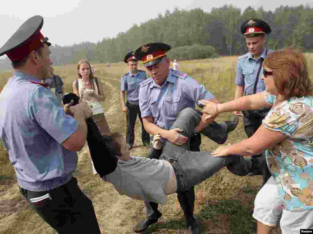 Russian police detain a protester for trying to prevent loggers from cutting down a section of the Khimki Forest. Activists have been trying to keep the forest from being cleared to make way for a highway between Moscow and St. Petersburg. Photo by Alexander Natruskin for Reuters