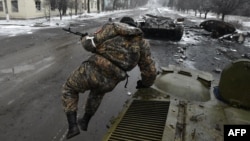 Проросійський бойовик стрибає з бронемашини поруч із розбитим українським танком у Вуглегірську, за 6 кілометрів на південний захід від Дебальцевого