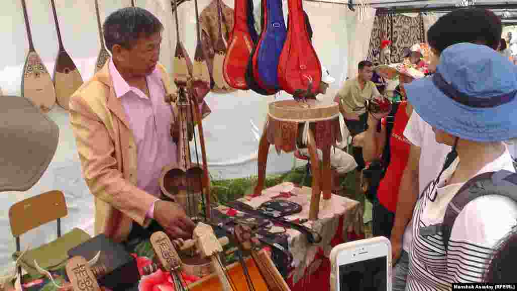 Мастер Даулетжан Усенулы показывает изготовленные им казахские народные музыкальные инструменты.&nbsp;