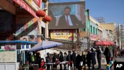 Жители проходят проверку у входа на рынок в Хотане, городе в провинции Синьцзян.