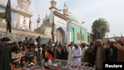 Relatives gather to attend funeral prayers on February 17 for victims killed in a suicide blast at the tomb of Sufi saint Syed Usman Marwandi, also known as the Lal Shahbaz Qalandar shrine, in Sehwan Sharif, Pakistan's southern Sindh Province.