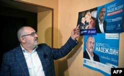 Борис Надеждин разговаривает с репортером AFP у своих предвыборных плакатов с прошлых региональных выборов. Россия, Московская область, Долгопрудный 24 января 2024 года