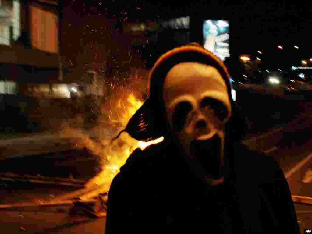 Замаскаваны удзельнік студэнцкіх пратэстаў у Коста-Рыцы. У панядзелак пачаліся сутычкі паміж паліцыяй і студэнтамі пасьля таго, як паліцыянты ўвайшлі ў студэнцкі гарадок Унівэрсытэту Коста-Рыкі, каб арыштаваць свайго калегу, якога абвінавацілі ў карупцыі.