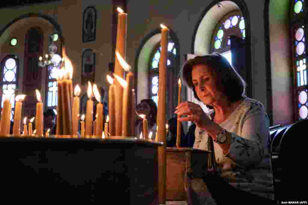 Një besimtare ndez qirinj në Kishën Ortodokse Greke të Shën Gjorgjit në Kajromë 10 prill gjatë të Premtes së Shenjtë.