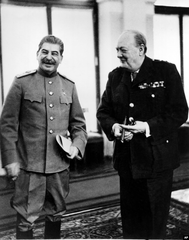 Советский маршал Иосиф Сталин (слева) и премьер-министр Великобритании Уинстон Черчилль смеются в конференц-зале Дворца Ливадия в Ялте, Крым, СССР, в феврале 1945 года во время Ялтинской конференции между тремя лидерами союзников во время Второй мировой войны