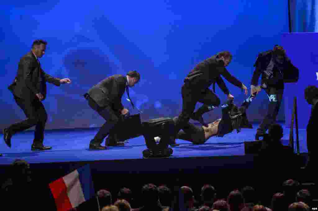 A Femen activist is evacuated by bodyguards as she protests during a speech by far-right presidential candidate Marine Le Pen at a rally in Paris on April 17. (epa/Christophe Petit Tesson)