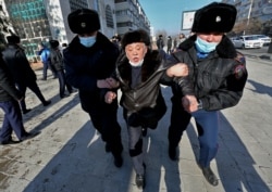 Полицейлер Республика алаңынан қарт адамды күштеп әкетіп барады. Алматы, 10 қаңтар 2021 жыл.