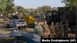 Soldați ai armatei sârbe stau în poziții lângă o dronă militară, în timpul unei expoziții de armament ca parte a unei sărbători recent instituite „Ziua Unității Sârbe”, Belgrad, 15 septembrie 2021. Imagine de arhivă.