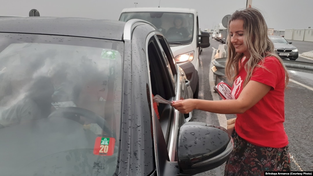 Membri ai organizației Salvați Copiii din Timiș împart flyere românilor întorși în țară pentru a-i face conștienți de responsabilitatea fașă de copiii lor lăsați în grija bunicilor.