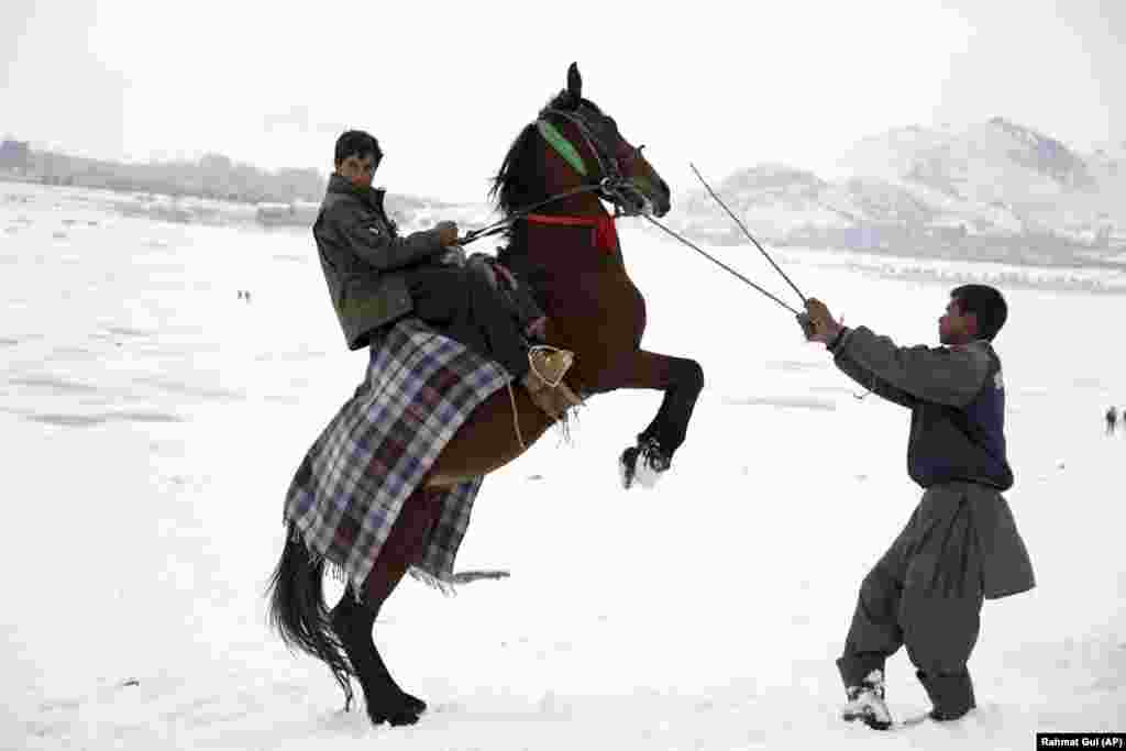 A man shows off his horse skills in an effort to attract customers to take a ride on the outskirts of Kabul. (AP/Rahmat Gul)