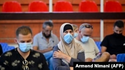 Disa njerëz pushojnë pasi morën dozën e parë të vaksinës kundër COVID-19 në një qendër vaksinimi në Prishtinë, 23 gusht 2021.