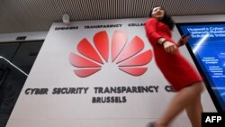 File photo: Belgium - A woman walks past a logo at the entrance of the European Huawei Cyber Security Transparency Centre during its opening in Brussels on March 5, 2019.