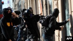 Protesters smash the window of a bank during a demonstration against corporate greed in downtown Rome on October 15. 